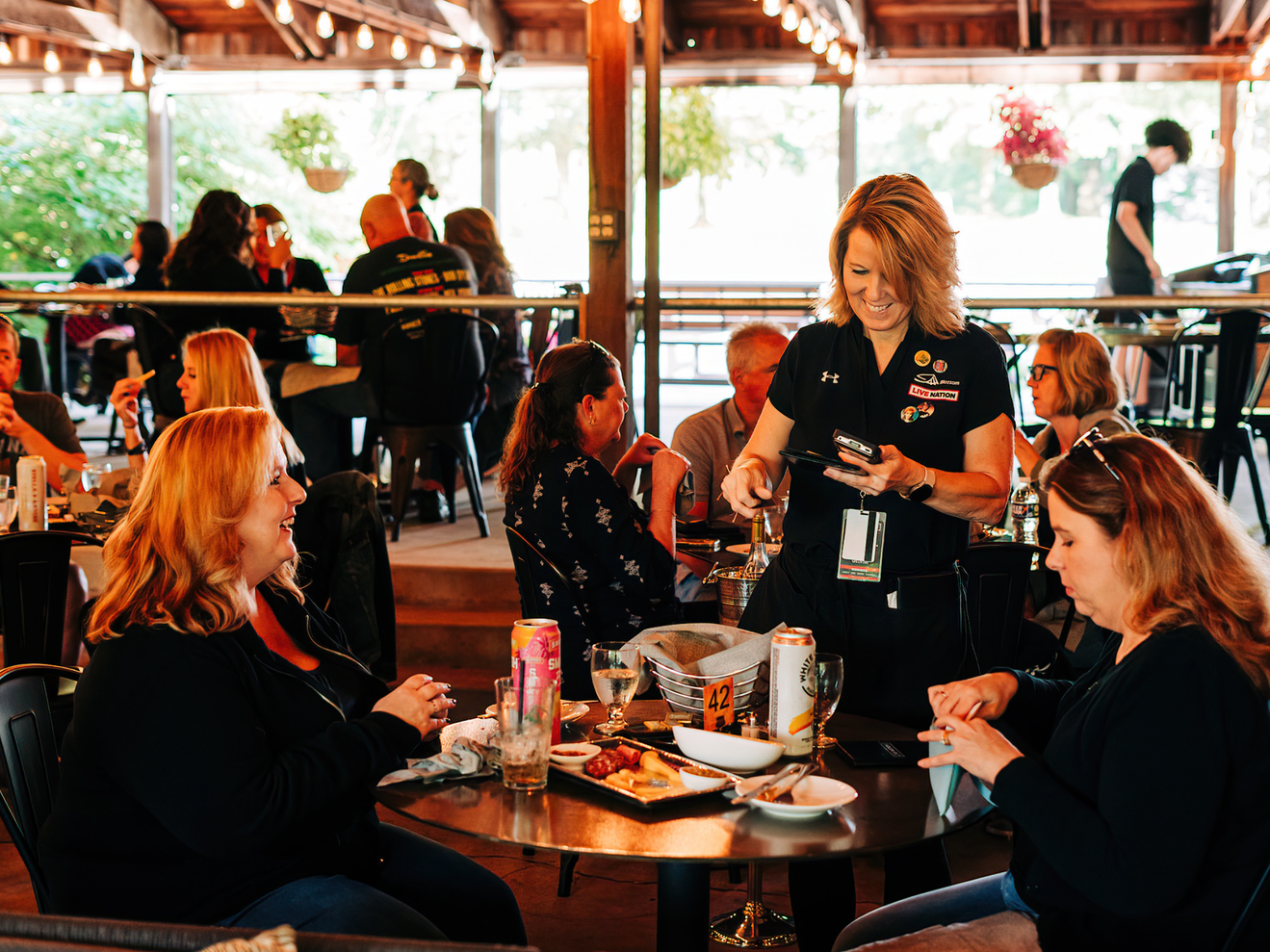 A couple of friends ordering from a server at a table at the Blossom Grille.