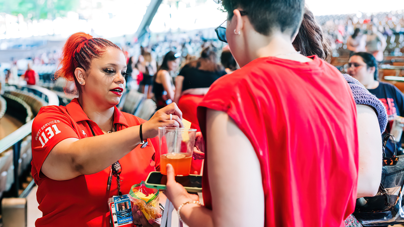 An usher helping out a fan to their seats in the pavilion of Blossom Music Center.