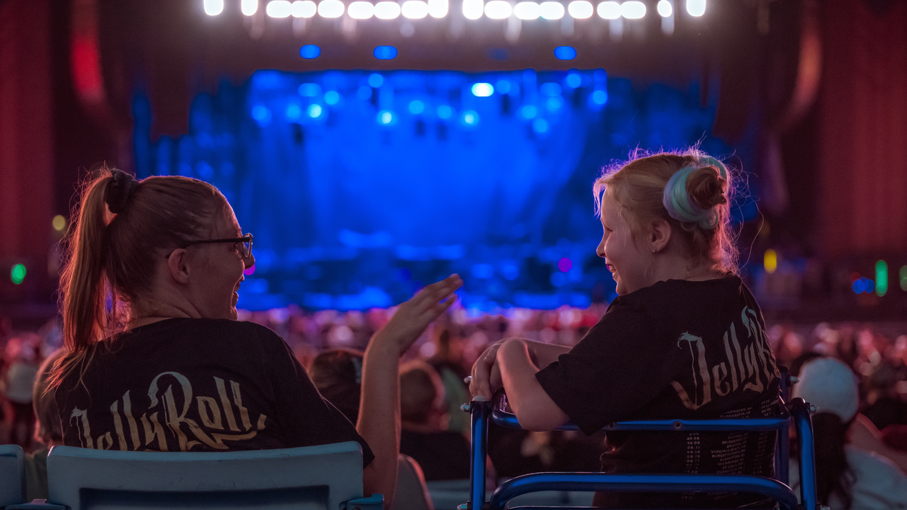An older woman and a young girl sitting in their seats, enjoying each other's company before the show starts.